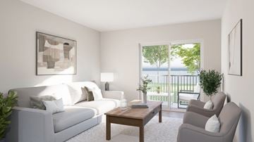 Ottawa apartment for rent - A living room with a white couch, a wooden table, and a painting on the wall.