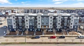 Calgary apartment for rent - A large apartment complex with a parking lot behind the buildings and street parking out front
