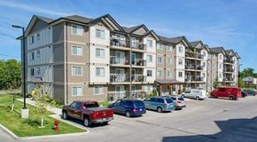 Selkirk apartment for rent - A row of apartment buildings with cars parked in front.