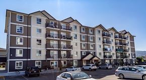 Penticton apartment for rent - A large apartment building with a parking lot in front