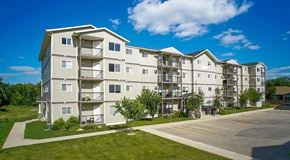 Winnipeg apartment for rent - A large apartment building with parking in front