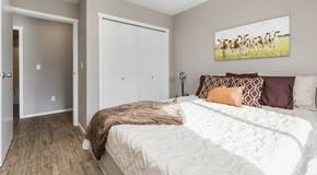 Lethbridge apartment for rent - A bedroom with a large bed and a painting of giraffes on the wall.