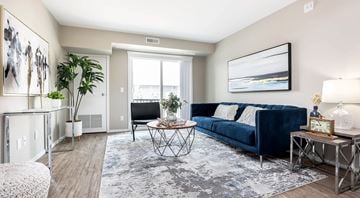 Selkirk apartment for rent - A living room with a blue couch and a painting on the wall.