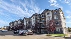 Edmonton apartment for rent - A large apartment building with a parking lot in front of it.