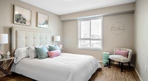 Saskatoon apartment for rent - A bedroom with a large bed and a chair.