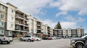 North Cowichan apartment for rent - A large apartment building with four storeys, a large parking lot in front