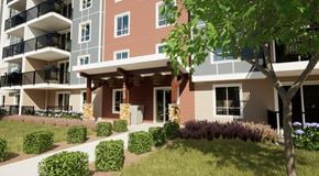 Orleans apartment for rent - A modern apartment building with a landscaped front yard.