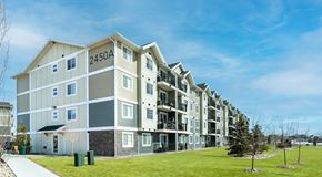 Red Deer apartment for rent - A large apartment building with green space in front