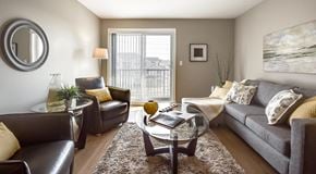 Edmonton apartment for rent - A living room with couch, coffee table and two arm chairs.