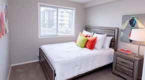 St. Albert apartment for rent - A bedroom with a large bed, nightstand and large window