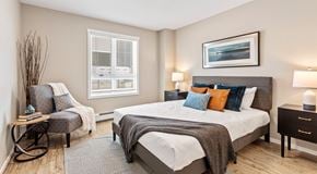 Orleans apartment for rent - A bedroom with a queen sized bed, a chair, and a nightstand.