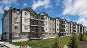 Edmonton apartment for rent - A four storey apartment building with a green space in front