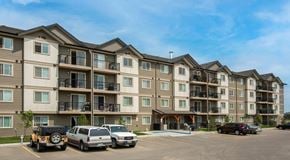 Edmonton apartment for rent - Apartment complex with cars parked in front.