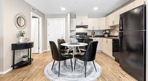 Orleans apartment for rent - A kitchen with light cabinets and black appliances, a round table sits in the centre