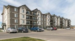 Beaumont townhouse for rent - A large apartment building with lots of parking out front