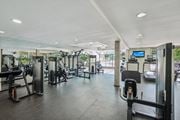 Rochester Hills townhouse for rent - Fitness center with cardio and weight machines and large windows at River Oaks at Rochester Hills Apartments.