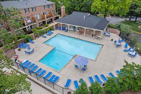 St. Louis townhouse for rent - Georgetown Apartments of St. Louis pool deck with blue lounge chairs, tables, and umbrellas.