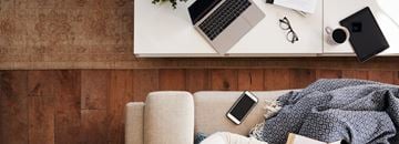 Las Vegas house for rent - A person is sitting on a couch with a laptop, a smartphone, glasses, and a cup on a table beside them.