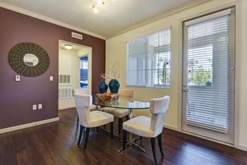 Vinyl plank flooring in a dining room with a table and chairs and a window