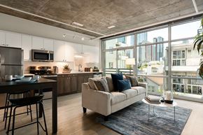 San Diego apartment for rent - A modern kitchen with a dining table and a couch with a view of the city.