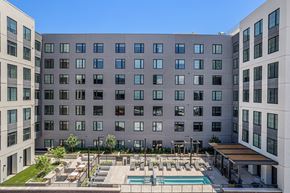 Denver apartment for rent - A large building with a pool in front.