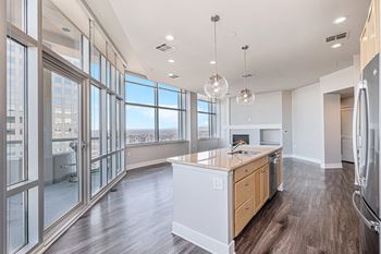 A modern kitchen with wooden floors and a large island.