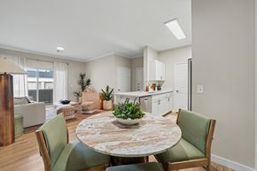 Lakewood apartment for rent - A dining room with a round table and green chairs.
