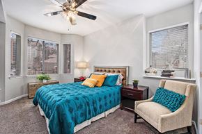 Glendale apartment for rent - A bedroom with a bed, chair, and ceiling fan.