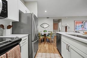 Lakewood apartment for rent - A modern kitchen with a dining table and chairs in the middle.
