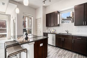 Denver apartment for rent - A kitchen with a black counter top and brown cabinets.
