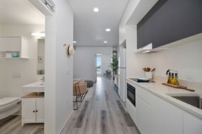 San Diego apartment for rent - a kitchen with white cabinets and a long hallway to a living room