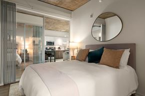 San Diego apartment for rent - A bedroom with a large bed and a round mirror on the wall.