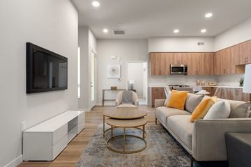 Los Angeles apartment for rent - A modern living room with a grey couch and a wooden coffee table.