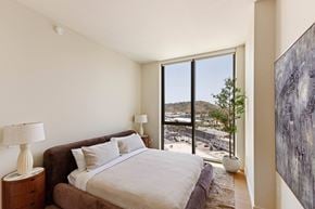 Los Angeles apartment for rent - A bedroom with a large bed and a view of the city outside the window.