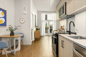 Los Angeles apartment for rent - A kitchen with a table and chairs and a clock on the wall.