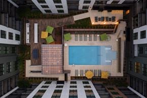Ashburn apartment for rent - A pool surrounded by yellow chairs and green plants.