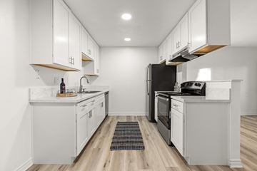 San Diego apartment for rent - A modern kitchen with white cabinets and stainless steel appliances.