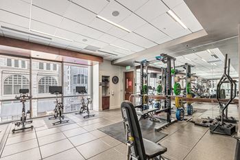 A gym with a variety of equipment including weights and exercise bikes.