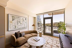 Los Angeles apartment for rent - A living room with a couch, a coffee table, and a large window overlooking a balcony.