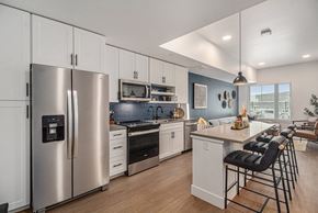 Denver apartment for rent - a kitchen with stainless steel appliances and a counter with chairs
