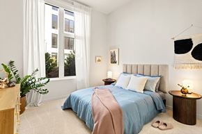 Los Angeles apartment for rent - A bedroom with a large bed and a window with white curtains.