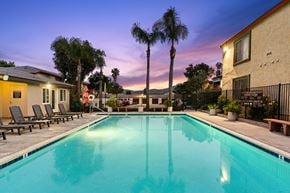 San Marcos apartment for rent - A swimming pool surrounded by palm trees and lounge chairs.