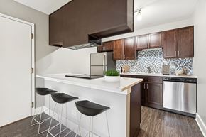 Aurora apartment for rent - A kitchen with a white counter and black stools.