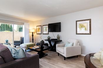 A living room with a couch and chairs and a tv