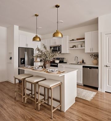Austin apartment for rent - A kitchen with a white island and bar stools.