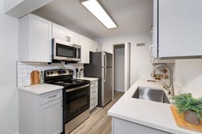 Littleton apartment for rent - a white kitchen with stainless steel appliances and white cabinets at Terra Vista at the Park Apartments, Littleton, CO, 80123