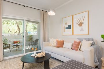 Chandler apartment for rent - A living room with a white couch, a coffee table, and a painting on the wall.