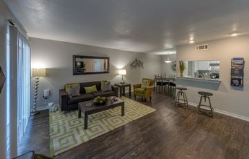 Houston apartment for rent - A living room with a green rug and a wooden floor.