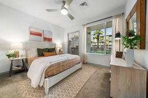 Phoenix apartment for rent - A bedroom with a bed, nightstand, and a plant on the side table at Bask Deer Valley apartment rentals in Phoenix, Arizona.