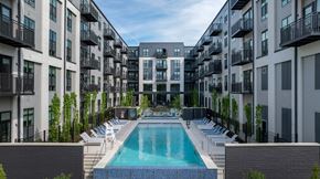 Annapolis apartment for rent - A swimming pool is surrounded by lounge chairs and apartment buildings.